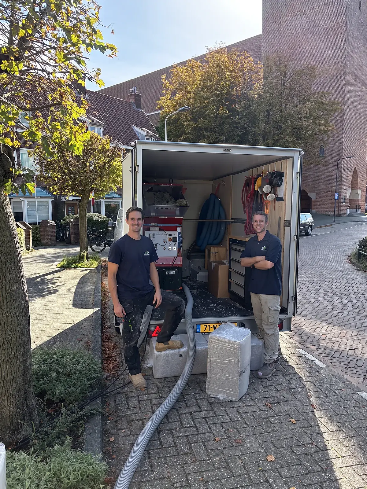 Edgar en Lars van Isoleer Natuurlijk bij hun aanhanger met inblaasmachine in Leiden