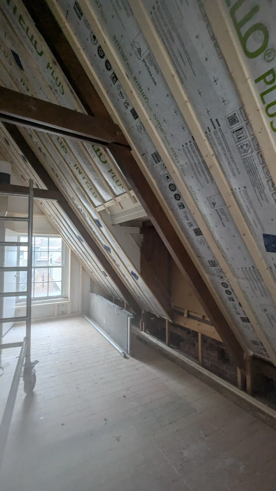Schuin dak in Delft met luchtdichte folie over de eiken spanten, klaar om cellulose in te blazen