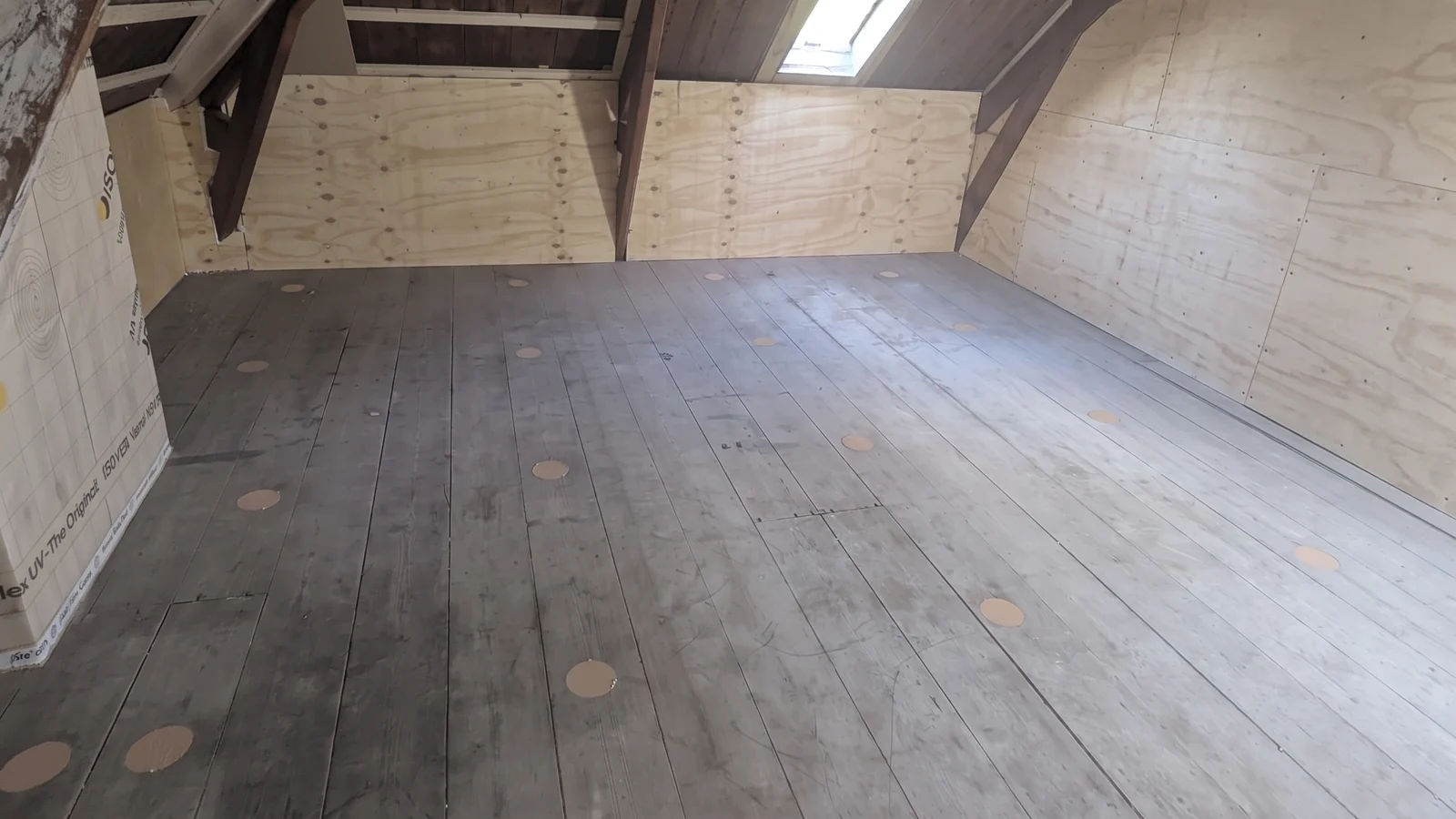 Zolder met houten vloer waarin de inblaasgaten zijn dichtgezet met conische kurken